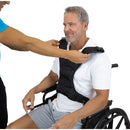 Caregiver fastening chest harness vest on patient for secure bed positioning, Moovkart.